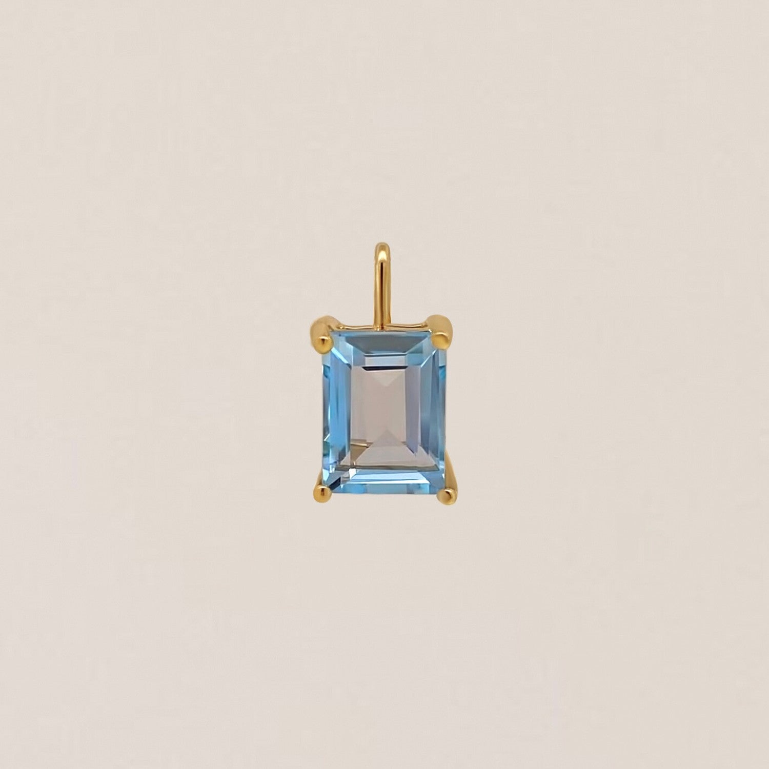 Gold pendant with a rectangular blue gemstone