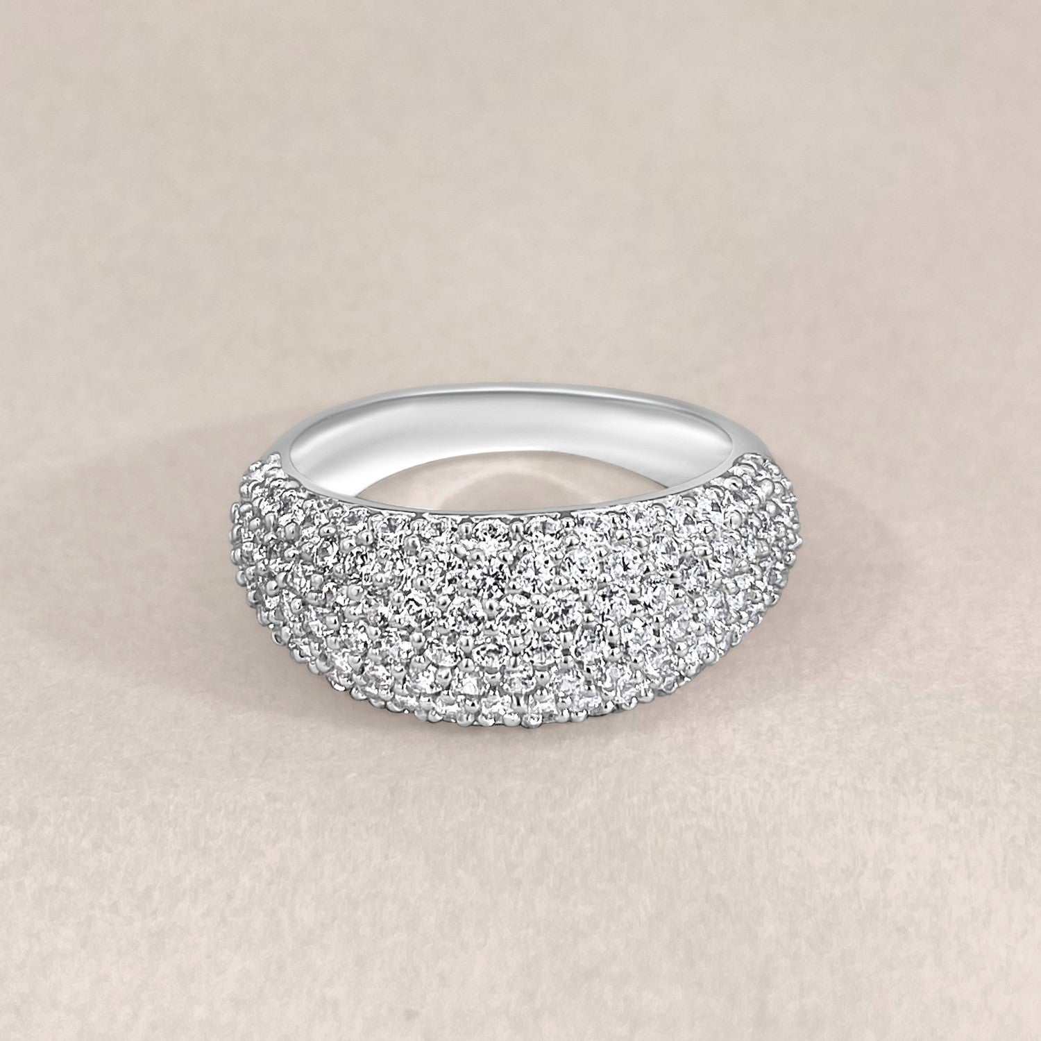 Silver ring with clear crystals on a beige background
